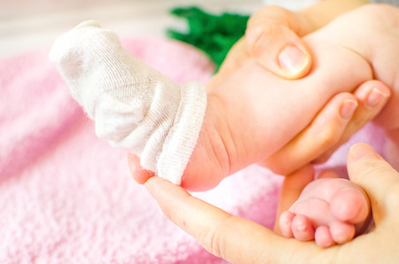 newborn baby dressing white socks little feetの写真素材