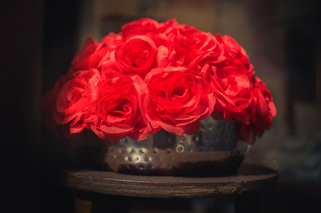 fake red roses shadows black background metallic potの写真素材