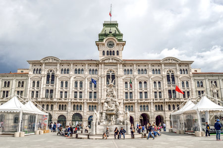 Trieste, Italy, June 1 2013:  people sit under the city hall building and the fountain of the Four Continents in the city's main squareのeditorial素材