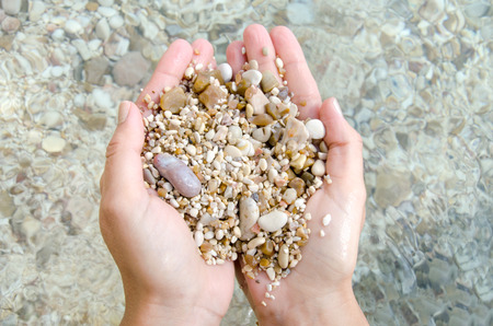 hand stones pebble beach seaの写真素材