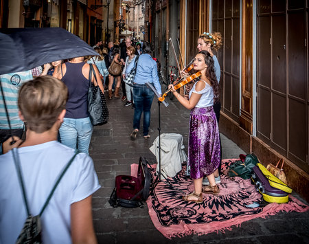 Bologna, Italy, 18 September 2016: two buskers violinists perform for the passersby in the historic district of Bologna.のeditorial素材