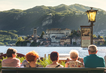 Orta, Italy, 21 May 2017 - senior tourists in Italy waiting for the ferry boat to San Giulio islandのeditorial素材