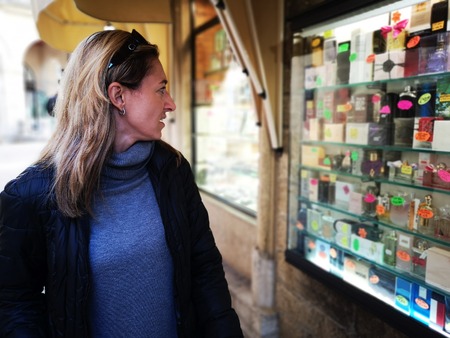 woman attracted by shop window of a perfumery display showcaseの写真素材