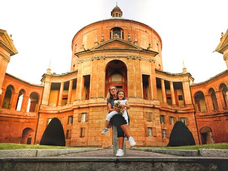 happy family in italy mother and daughter at the San Luca sanctuary church of Bologna in Emilia...