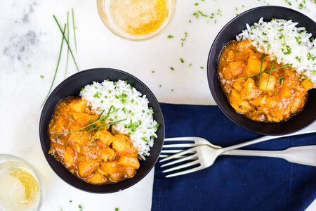 Curry chicken on black bowls and beer.の写真素材