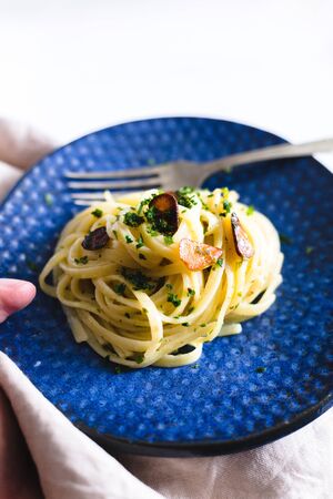 Aglio e Olio pasta in a blue ceramic.の写真素材