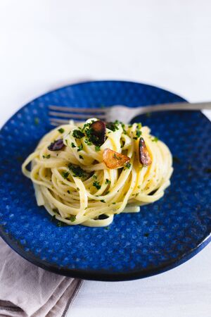 Aglio e Olio pasta in a blue ceramic.の写真素材