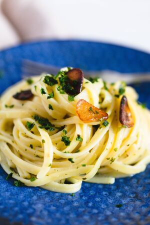Aglio e Olio pasta in a blue ceramic.の写真素材