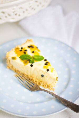 Paasion fruit cheesecake on a cute ceramic on a marble surface.の写真素材