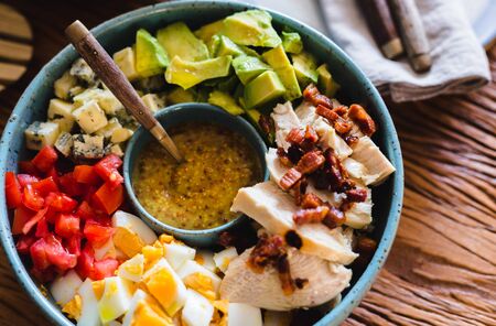 Homemade cobb salad on a rustic wood surface.の写真素材