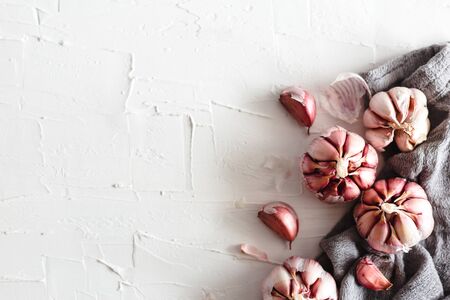 Garlic on a white plaster surface.の写真素材
