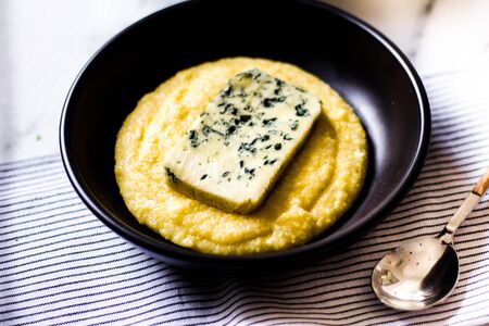 Polenta with blue cheese and black ceramic.の写真素材