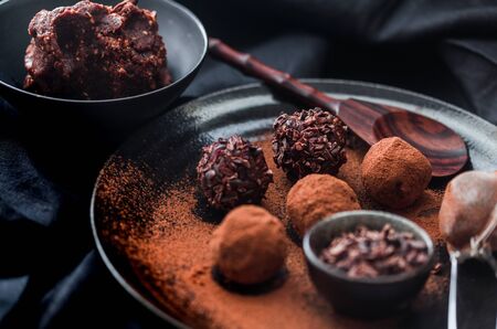 Date energy ball with cocoa on a black dish and cocoa nibs.の写真素材
