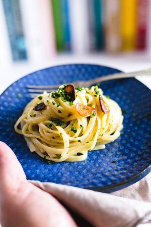 Aglio e Olio pasta in a blue ceramic.の写真素材