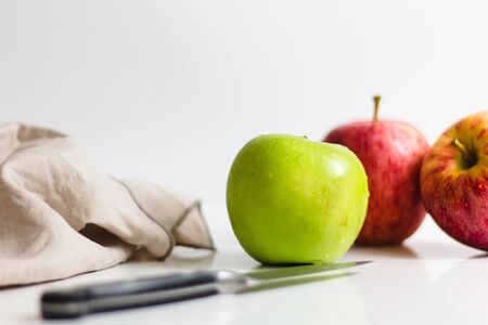 Green and red apple being prepared with knife and being peeled.の写真素材