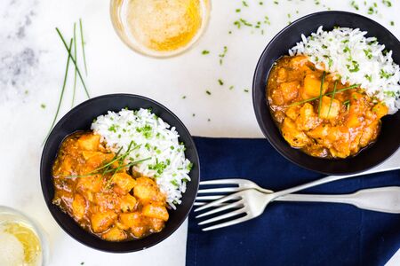 Curry chicken on black bowls and beer.の写真素材