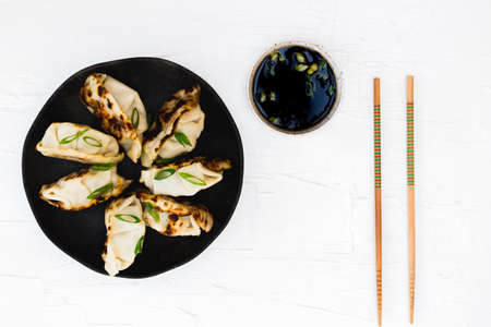 Asian dumplings with soy sauce and chopsticks.の写真素材