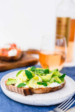 Raw zucchini and goat cheese crostini with mint leaves.の写真素材