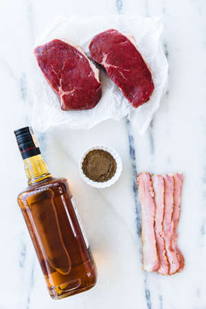raw steaks with bourbon, bacon and brown sugar food knolling.の写真素材