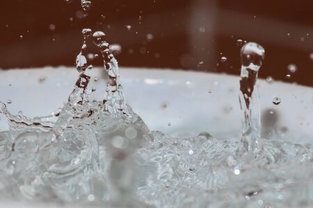 close-up of the impact of a drop of water in a container full of waterの写真素材