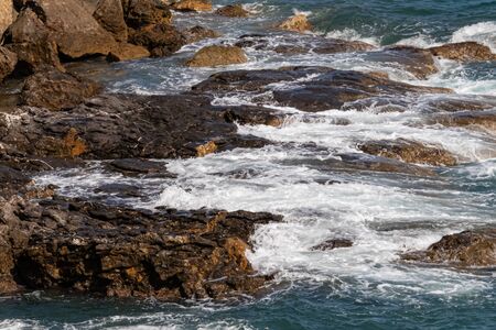sea ?? waves beating on the cliff creating many splashes, ligurian sea, italy
