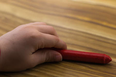 little child hand holding a pencilの写真素材