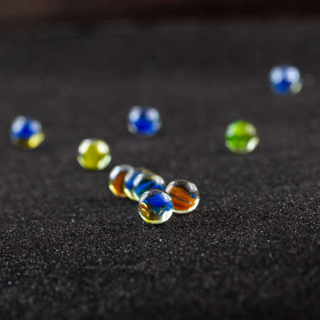 colored glass marbles on dark background