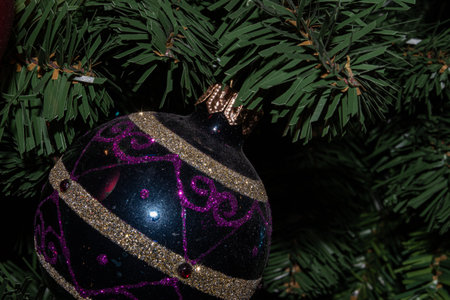 Christmas tree decorated with baubles and garlands on a dark background.の写真素材