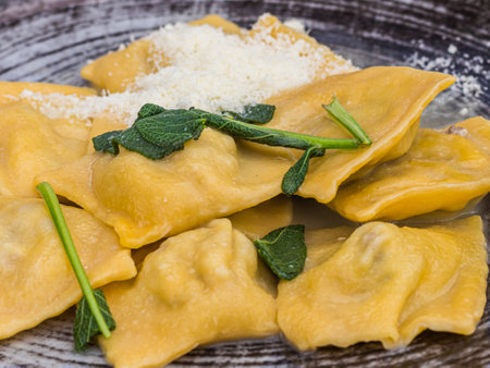 Boiled ravioli with spinach and parmesan on wooden backgroundの写真素材