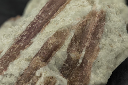 Reddish Tourmaline stone on matrix against Black Background
