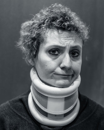 Head shot portrait of beautiful woman with cervical collar, young female patient looking at camera,...