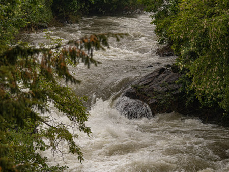 shot of a mountain stream swollen with water due to heavy rainsの写真素材