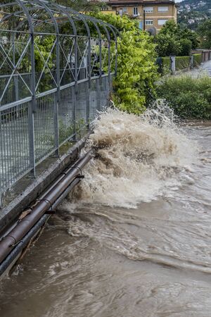 swollen river after a storm with the waters touching the bridgeの写真素材