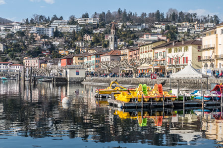 Ascona, Switzerland - 05-14-2019: Panorama of Ascona with houses with colorful facades reflecting on...