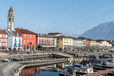 Ascona, Switzerland - 05-14-2019: Panorama of Ascona with houses with colorful facades reflecting on...