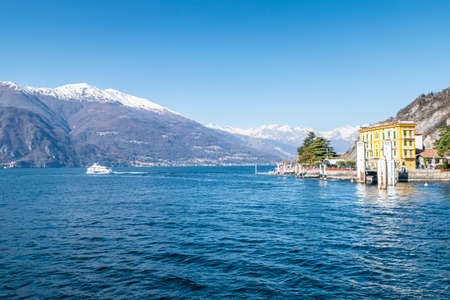 The Varenna pier with the snow-capped alps in the backgroundの写真素材