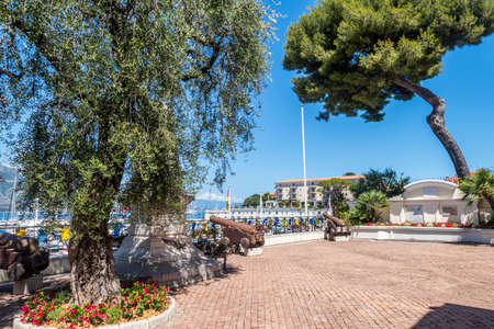 Saint Jean, France - 07/04/2021: The main square of Saint Jean Cap Ferrat with a monument, an olive tree and ancient cannonsのeditorial素材