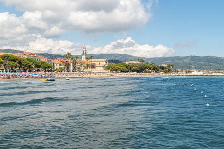 Diano Marina, Italy - 10-07-2021: The beach of Diano Marina with a beautiful church in backgroundのeditorial素材