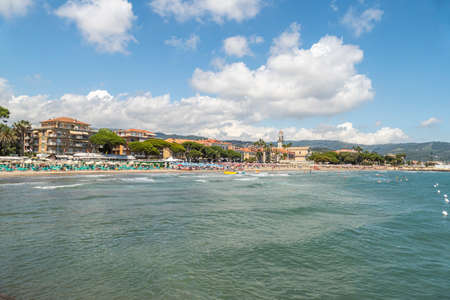 Diano Marina, Italy - 10-07-2021: The beach of Diano Marina with a beautiful church in backgroundのeditorial素材