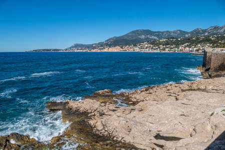 The beautiful Balzi Rossi beach in Ventimiglia with Menton in the backgroundの写真素材