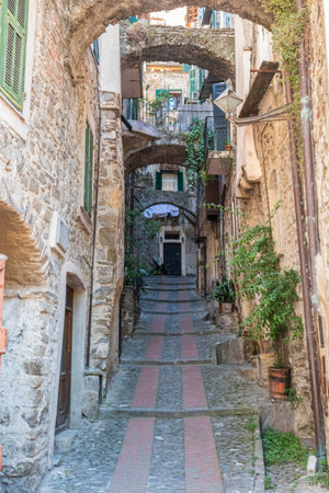 Dolceacqua, Italy - 06-07-2021: Characteristic small streets in the historic center of Dolceacqua with arches and flowersのeditorial素材