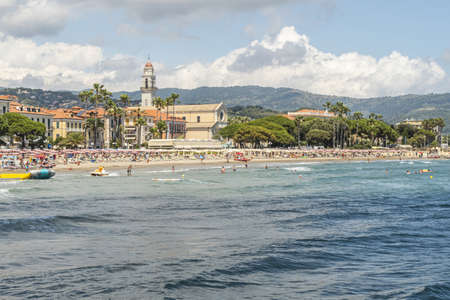 Diano Marina, Italy - 10-07-2021: The beach of Diano Marina with a beautiful church in backgroundのeditorial素材