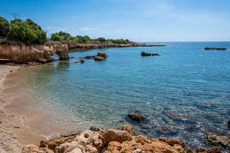 Beautiful beach with crystal clear water and a natural rock arch in Sicily in Syracuseの写真素材