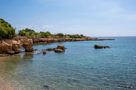 Beautiful beach with crystal clear water and a natural rock arch in Sicily in Syracuseの写真素材