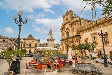 Scicli, Italy: 09-18-2022: The beautiful Busacca Square in Scicli with monument and churchのeditorial素材