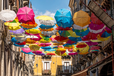 Catania, Italy - 09-23-2022: beautiful street in the center of Catania with many colorful umbrellas hanging over the streetのeditorial素材
