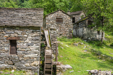 Stone watermill with wooden wheel in an abandoned mountain village in the Alpsの写真素材
