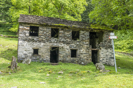 Ruined stone houses and mills in an abandoned mountain village in the Alps