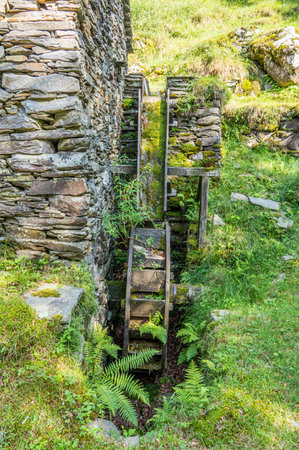 Stone watermill with wooden wheel in an abandoned mountain village in the Alpsの写真素材