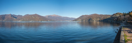 Extra wide angle view of the promenade on the lake in Luino with the mountains in the backgroundの写真素材